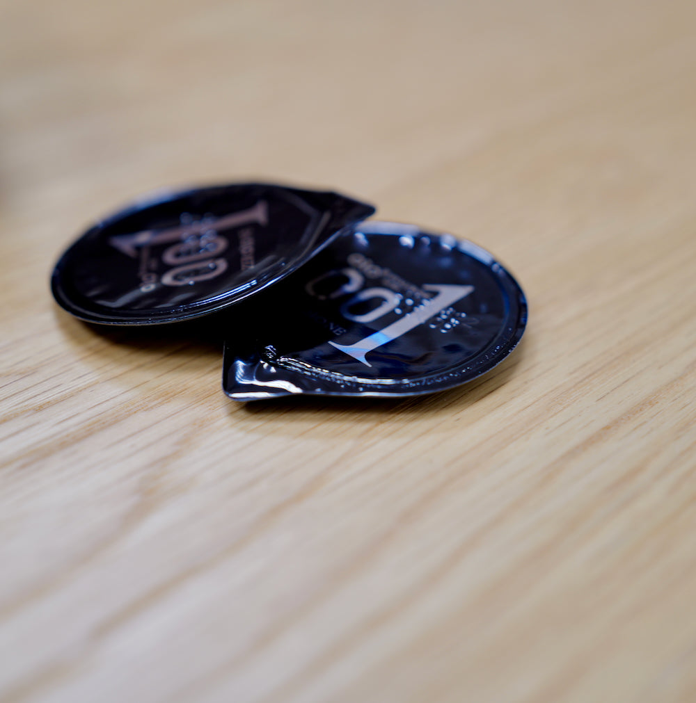 Black OLO condom wrapper on a wooden table, close-up