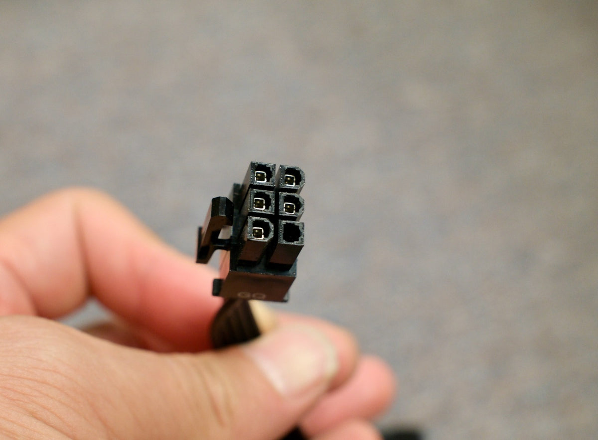 Hand holding the 6-pin power supply connector of the EVGA SATA cable