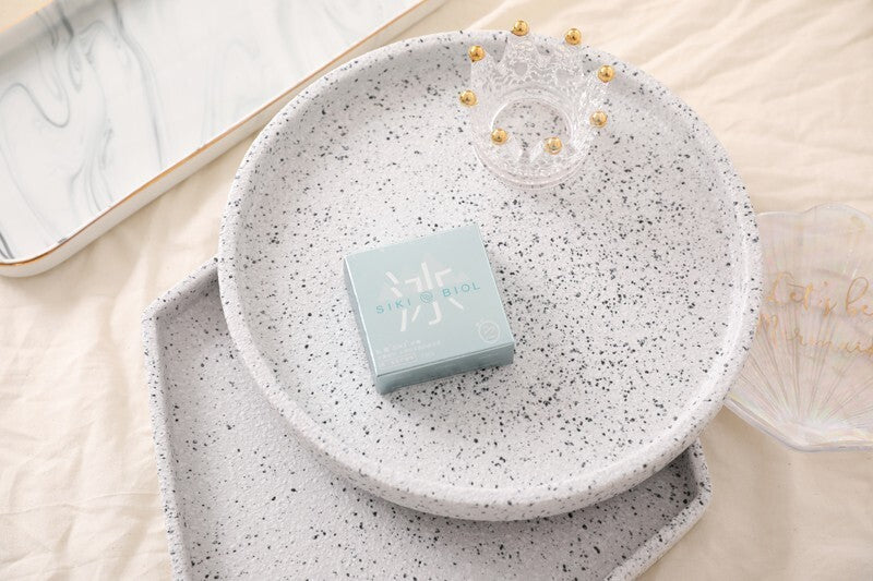 SIKI 003 light blue retail box on a speckled plate
