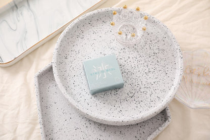 SIKI 003 light blue retail box on a speckled plate